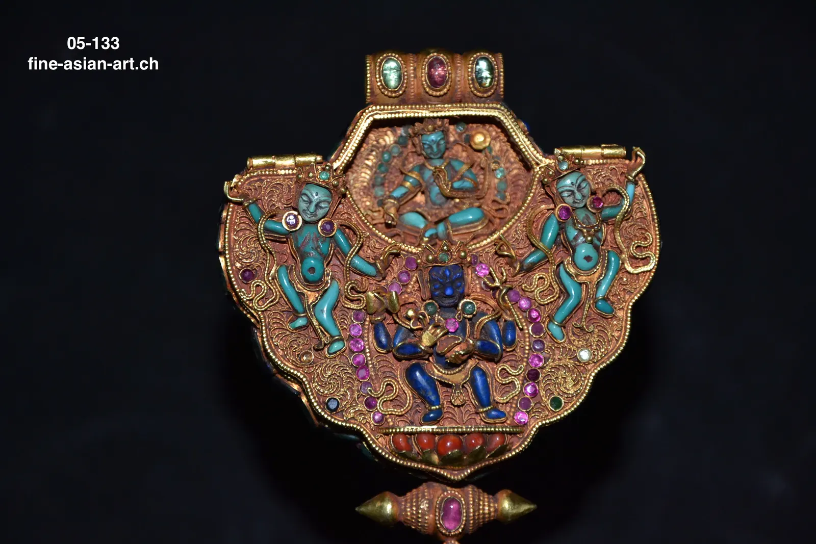 Geöffnete goldene Amulettbox mit graviertem Deckel, rotem Innenraum, kleiner Figur und Anhänger