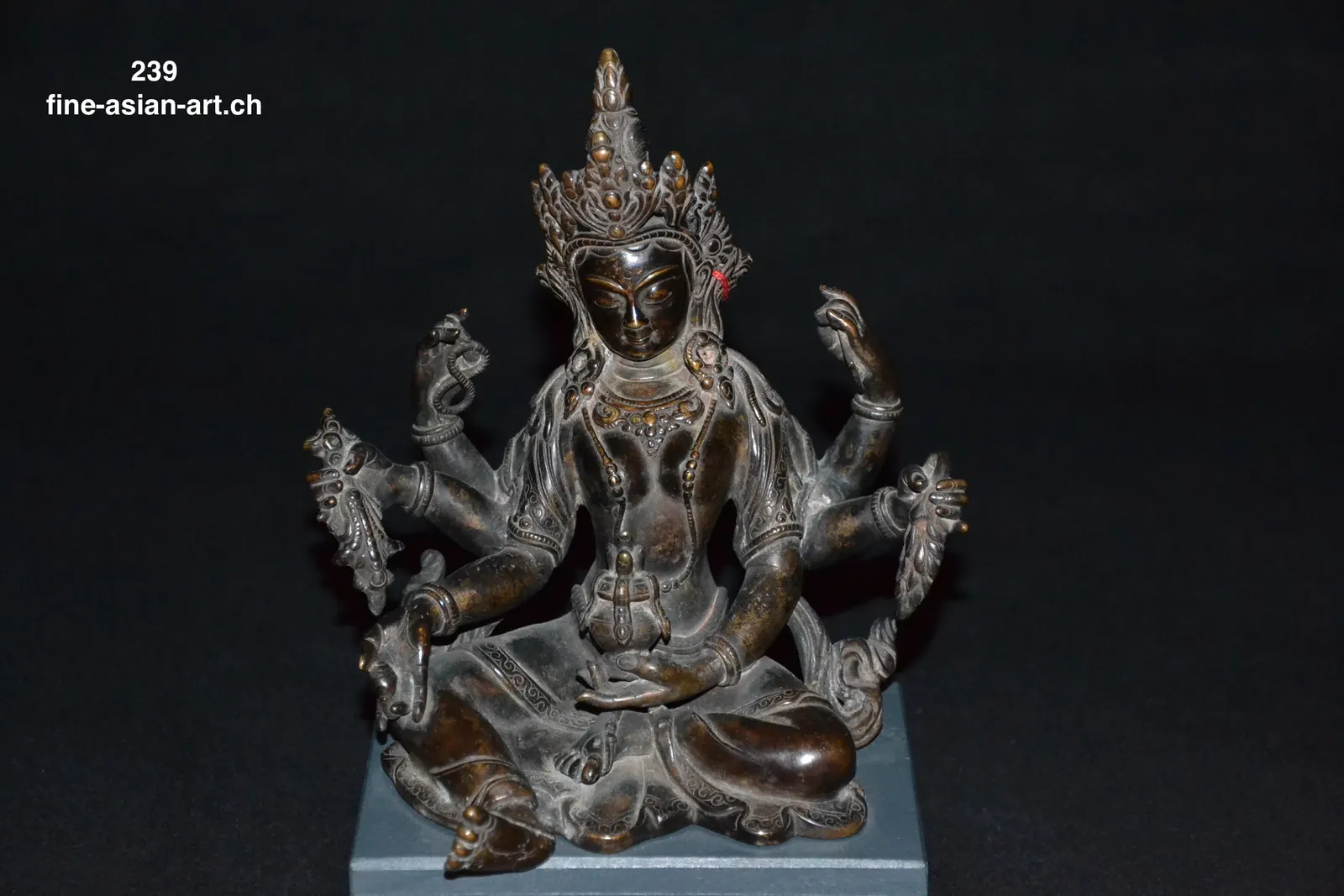 Sechsarmige Vasudhara aus dunkler Bronze, sitzend mit hoher Krone